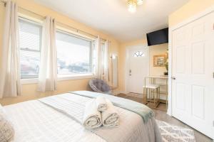 a bedroom with a bed with towels on it at Chic Groton Studio • A Cozy, Modern & Central Gem in Groton