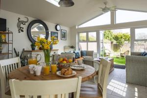a kitchen and dining room with a table and chairs at Haven House in Lymington