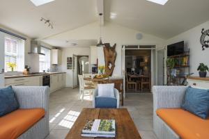 a kitchen and living room with two couches and a table at Haven House in Lymington