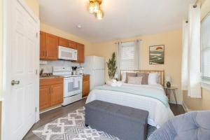 a bedroom with a bed and a kitchen at Chic Groton Studio • A Cozy, Modern & Central Gem in Groton