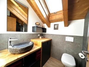 a bathroom with a stone sink on a wooden counter at Appartamento Picchio in Bormio +7 photos