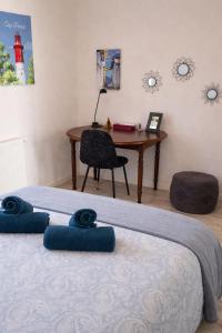 a bedroom with a desk and a bed and a table at T3 centre La Teste-de-Buch Terrasse 2 parkings Wi-Fi fibre 4 pers in La Teste-de-Buch
