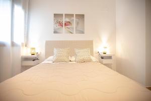 a bedroom with a large bed with two pillows at Sweet Inas in Sitges +12 photos
