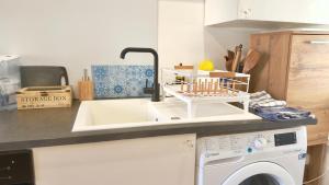 a kitchen with a sink and a washing machine at Le Talantueux in Talant