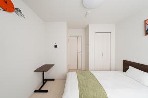 a bedroom with a bed and a desk at SAIEI Hotel 东京小岩 JR京成双站直达成田羽田迪士尼适合家庭团队整栋多房型 in Tokyo
