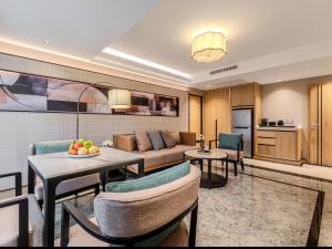 a living room with a couch and a table and chairs at Samala Suites Bangkok Sukhumvit 19 by Kingston Hotels in Bangkok