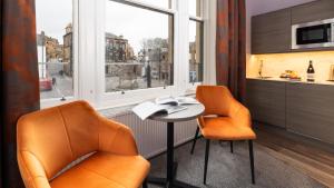 two chairs and a table in a room with a window at Linen Bank Residence - Aparthotel in Linlithgow