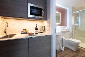 a bathroom with a sink and a toilet and a microwave at Linen Bank Residence - Aparthotel in Linlithgow +183 photos