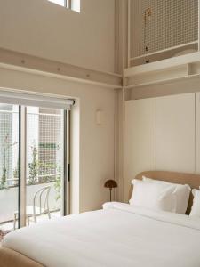 a bedroom with a large white bed and a window at LIOZ Hotel & Apartments in Lisbon