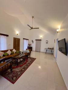 a living room with a couch and a tv at Green Castle in Gonikoppal