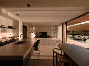 a kitchen and living room with a view of a pool at Haven Lake Village in Kortenhoef