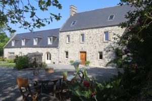 a stone house with a table in front of it at Gite de la Mare de la Trémaillerie in Blainville-sur-Mer