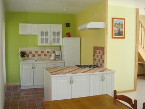a kitchen with white cabinets and a white refrigerator at Gite de la Mare de la Trémaillerie in Blainville-sur-Mer