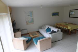a living room with two chairs and a couch and a table at Gite de la Mare de la Trémaillerie in Blainville-sur-Mer