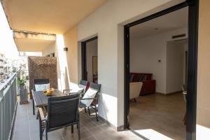 a balcony with a table and chairs and a living room at Sweet Inas in Sitges