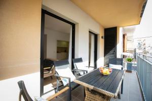 a balcony with a wooden table and chairs on a balcony at Sweet Inas in Sitges