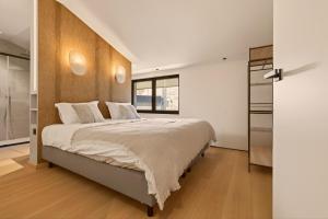 a bedroom with a large bed with a wooden headboard at Lakeside Lodges - Gîte 6 personnes à 10 min circuit Spa Francorchamps in Jalhay