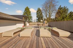 a deck with a table and chairs on it at Lakeside Lodges - Gîte 6 personnes à 10 min circuit Spa Francorchamps in Jalhay