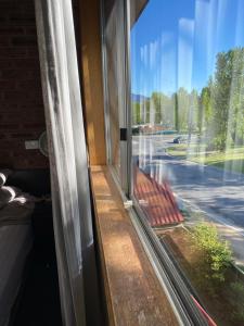 a window with a view of a street at Alpine Gables Apartment in Jindabyne