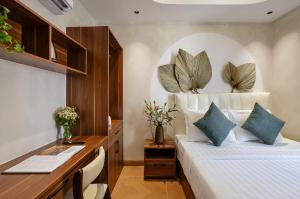 a hotel room with a bed and a desk and a desk at Jan Casa in Ho Chi Minh City