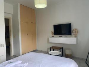 a bedroom with a bed and a flat screen tv at Rethymno Blue Residence in Rethymno
