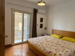 a bedroom with a bed and a sliding glass door at Maison de Lama - Expat friendly, AirCon, Garden access in Cairo