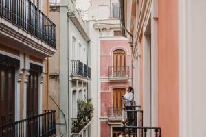 a woman standing on a balcony of a building at Signa Juristas in Valencia