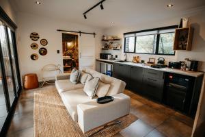 a living room with a couch and a kitchen at Wagyu Mountain Lodge in Paarl