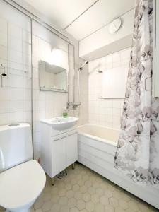 a bathroom with a toilet and a sink and a tub at Savonlinna City Apt Central in Savonlinna