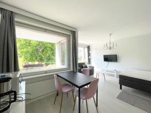a living room with a table and chairs and a window at Savonlinna City Apt Central in Savonlinna