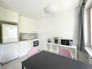 a kitchen with a table and two pink chairs at Savonlinna City Apt Central in Savonlinna