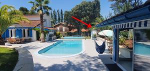a house with a swimming pool with a hammock next to a house at Studio proche de l'Océan - Calme et Pratique in Capbreton
