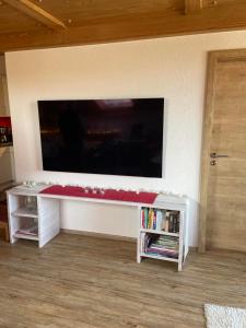 a living room with a large tv on a wall at Ferienwohnung Hörnernest in Bolsterlang