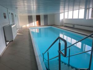 a large swimming pool with a staircase in a building at Ferienwohnung Hörnernest in Bolsterlang
