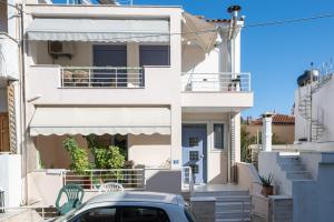 a white house with a car parked in front of it at Panorama City Loft in Mytilene