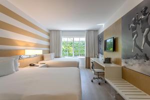 a hotel room with two beds and a desk at Pestana South Beach Miami in Miami Beach +46 photos