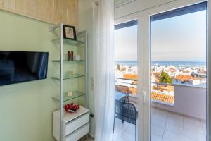 a room with a view of a balcony with a television at Panorama City Loft in Mytilene