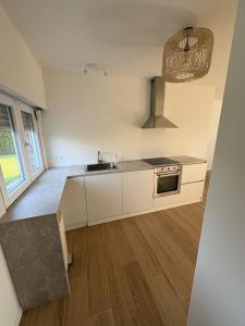 a kitchen with white cabinets and a sink at De Boomgaard in Nieuwerkerken