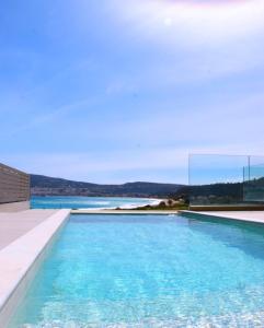 a swimming pool with a view of the water at Relaxury Villa II in Karpathos