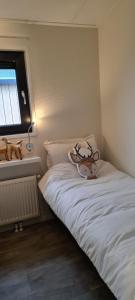 a small bedroom with a white bed and a window at Het Wellnesstje in Teuge +9 photos
