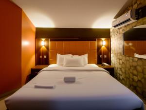 a bedroom with a large white bed with lights on it at Aotel Hotel Lagos Ago in Lagos
