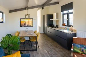 a kitchen and dining room with a table and chairs at Het Wellnesstje in Teuge
