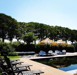 a group of chairs and tables next to a pool at Het Wellnesstje in Teuge