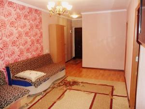 a living room with a couch and a chandelier at Ахметова 10 in Krasnoye Pole