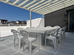a white table and chairs on a patio at VILLA TSUKUNAMI aoshima in Miyazaki