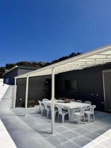 a patio with a table and chairs under a roof at VILLA TSUKUNAMI aoshima in Miyazaki