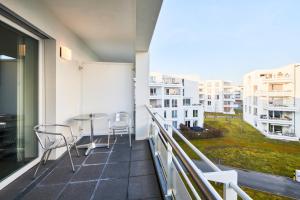 a balcony with chairs and a table on a building at ADAPT APARTMENT HOTEL Giessen in Gießen