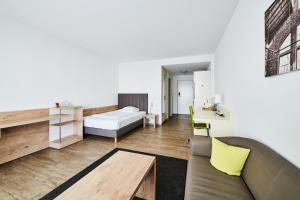 a living room with a bed and a table at ADAPT APARTMENT HOTEL Giessen in Gießen