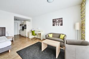 a living room with a couch and a table at ADAPT APARTMENT HOTEL Giessen in Gießen