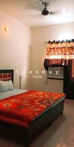 a bedroom with a bed with a red comforter at SGroom in Amritsar +1 photo